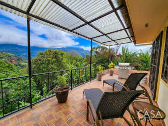 Covered patio terrace with tile floor, planter boxes and panoramic view of El Salto mountains in Boquete Panama