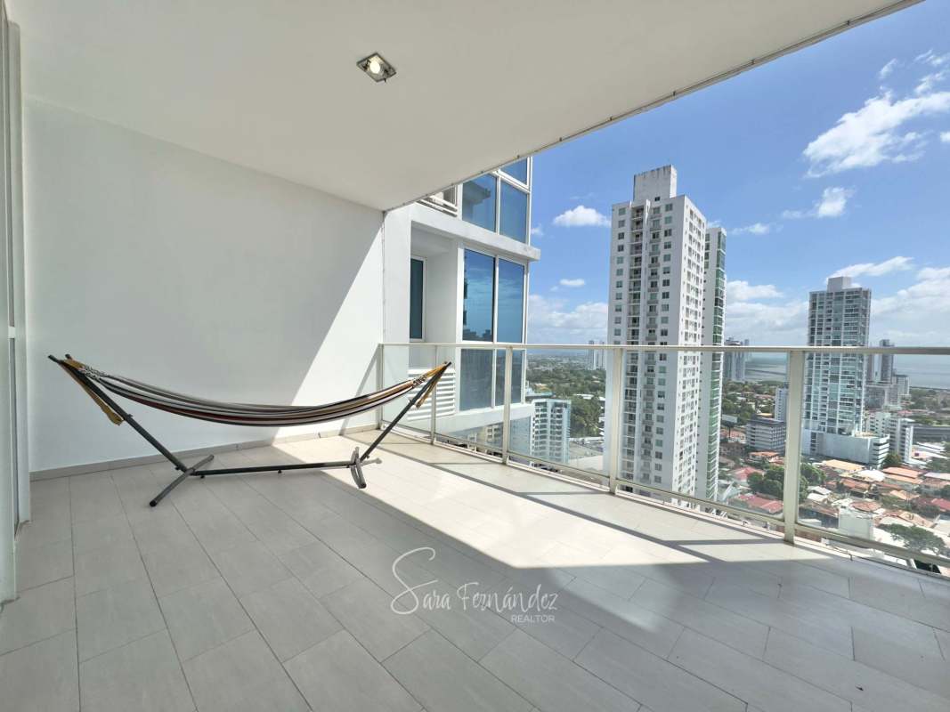 Bright open-concept living and dining room with floor-to-ceiling windows and skyline views