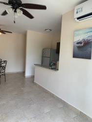 Contemporary open living dining and kitchen with tile floors in Playa Dorada Panama apartment