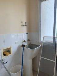 Compact laundry room with sink, mop, window Playa Dorada Panama beachfront apartment