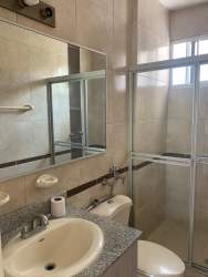 Bathroom with walk-in glass shower, granite counter in Playa Dorada apartment Panama