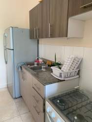Compact kitchen granite surfaces, cabinets, appliances Playa Dorada apartment in Panama