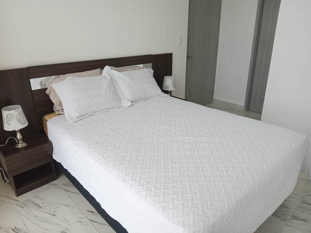 Minimalist furnished bedroom with bed set, tile floors, and ocean views PH The Sands Panama