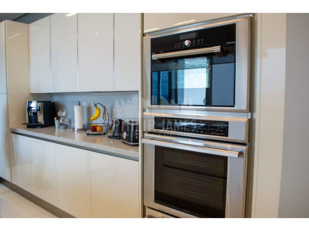 Modern bathroom with double sink, glass shower and marble finishes at Ten Tower