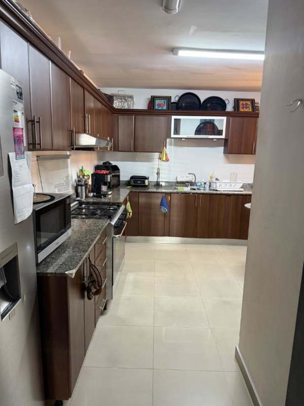 Spacious kitchen with wood cabinets, granite counters and appliances in PH Sophia Tower apartment Obarrio Panama