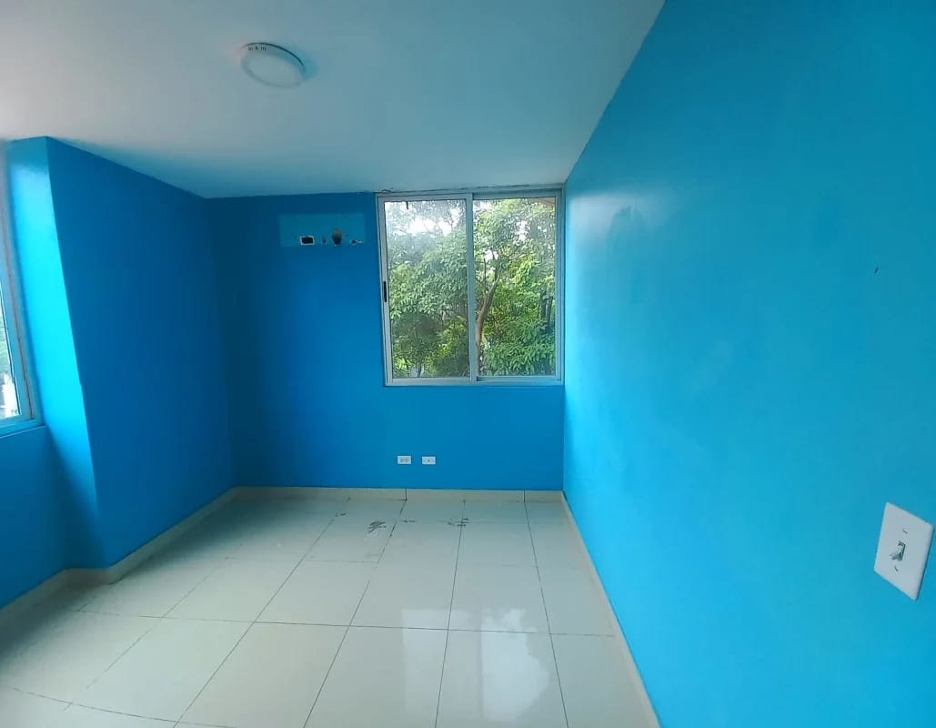 Spacious bedroom with large window and blue painted wall in PH Creta Chanis Panama