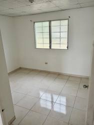 Empty bedroom with large window, white walls, and tile floor in Quintas del Pacífico La Chorrera Panama