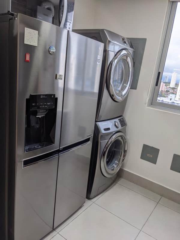 Laundry room with refrigerator, stacked washer dryer, window city view in PH Park City Obarrio Panama