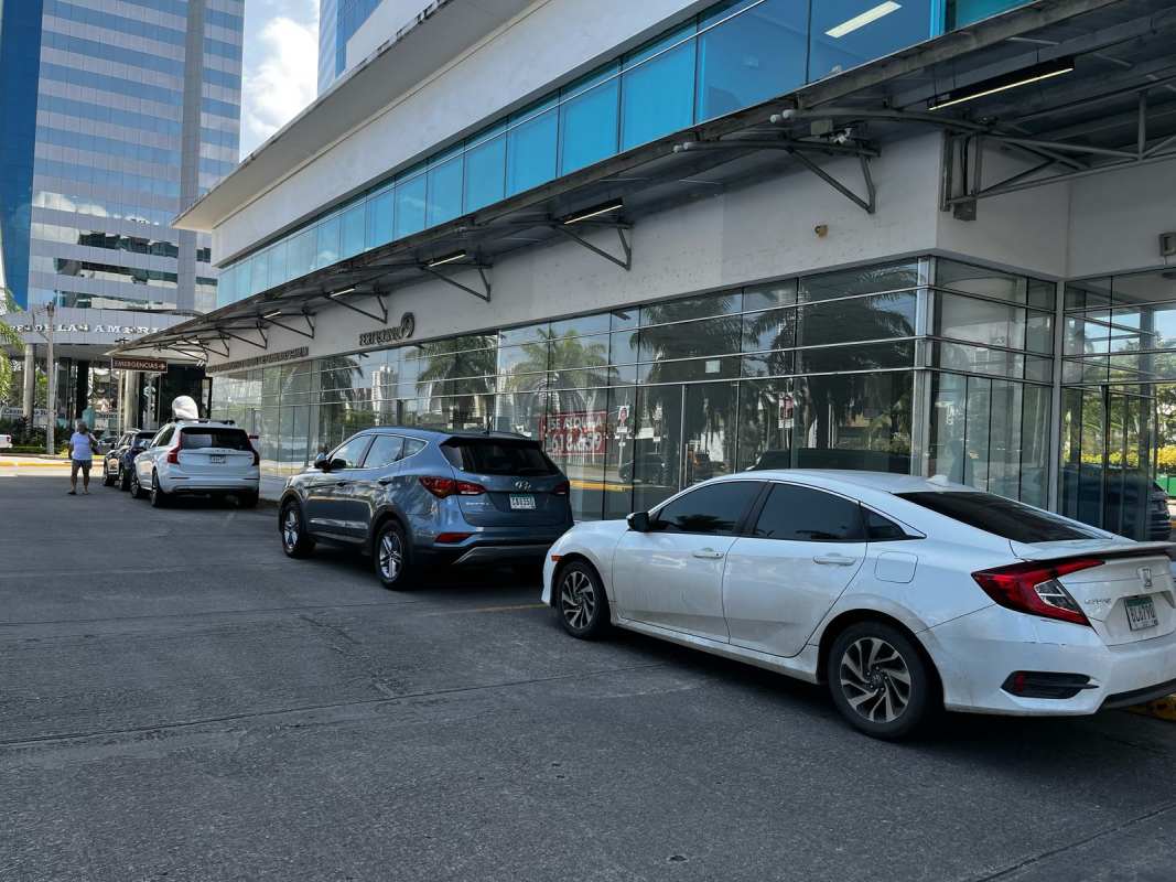 Pacific Salud Tower commercial storefront with glass facade reflecting palm trees and street activity
