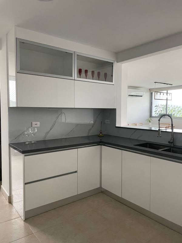 L-shaped modern kitchen with marble backsplash in furnished apartment at Clayton Park Residences