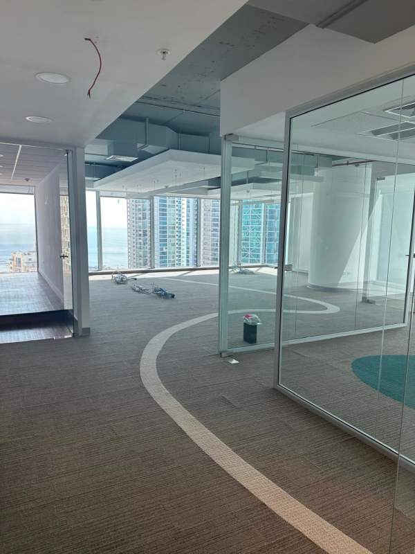 Glass-partitioned open plan office with cityscape views in Oceanía Business Plaza Panama