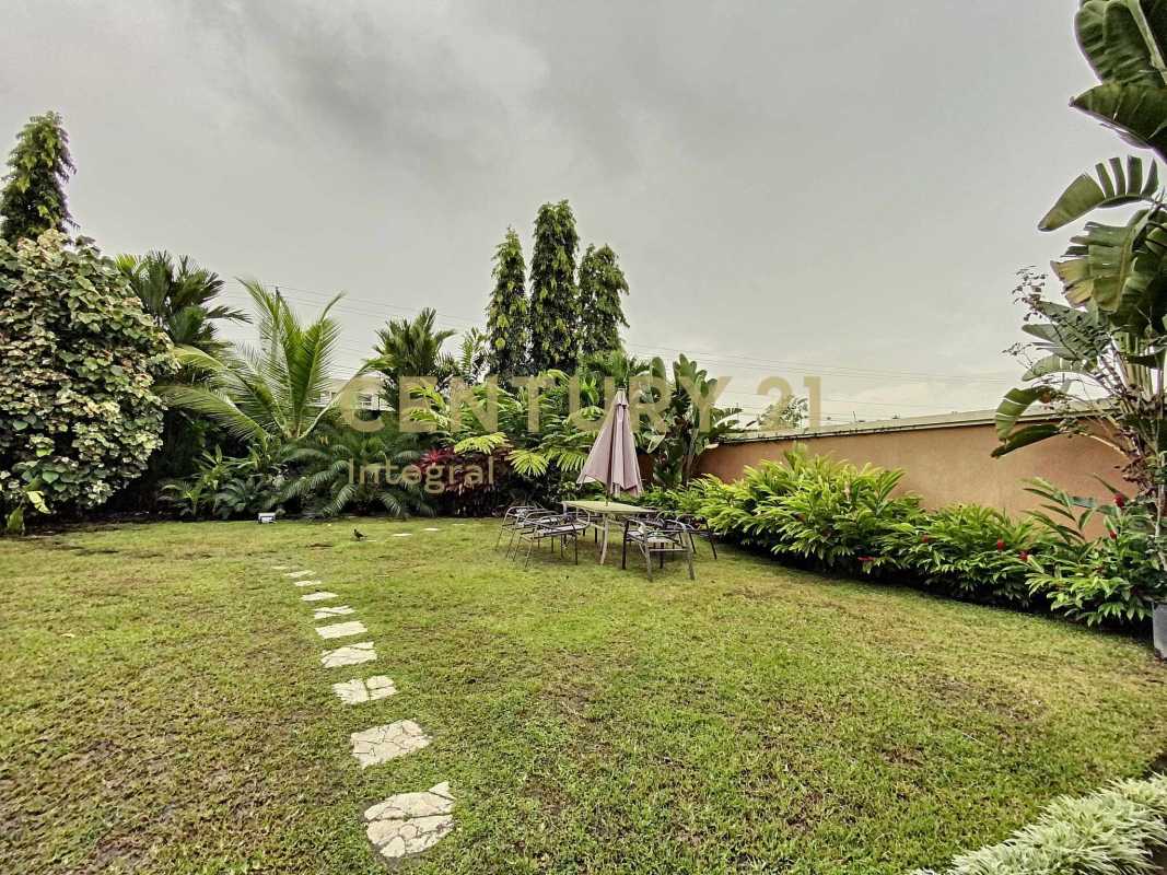 Private tropical backyard with patio furniture, lawn, and privacy wall in PH Sunset Coast Costa Sur Panama