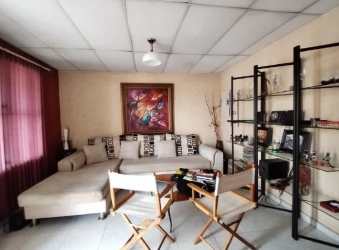 Living room with sectional sofa, wall art, window curtains in house Veracruz Arraiján Panama