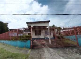 Dining room with red accent wall, window blinds, pendant light and musical decorations in home Arraiján Panama