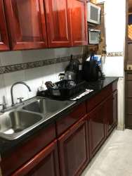 Kitchen featuring granite countertops, double sink, red wooden cabinets in Veracruz Arraiján Home for Sale