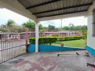 Covered entrance patio with metal gate, garden and paved yard in Residencial La Estancia Arraiján Panama
