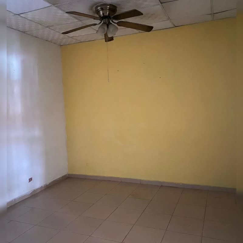 Empty bedroom with built-in wardrobe, tile floor, ceiling fan, security bars, Villa Lucre Panama