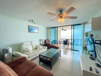 Bright living room with large glass doors to terrace, ceiling fans, tiled floors in Coronado Panama condo
