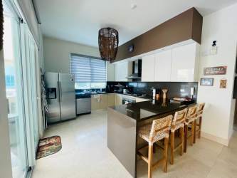 Modern dining space with large windows near kitchen in PH Balboa V oceanfront apartment Bijao Panama