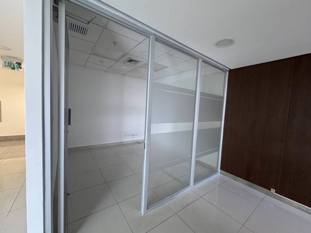 Glass partition enclosed offices with tile flooring in modern corporate tower Costa del Este Panama