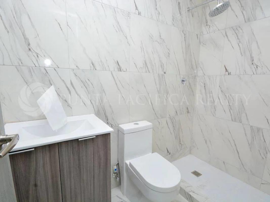 Elegant bathroom with marble tile walls and modern fixtures in PH El Botánico Panama City