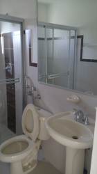 Bathroom with glass shower enclosure, pedestal sink, and toilet in Playa Dorada house Panama