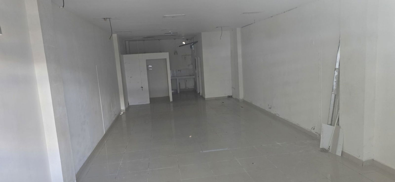 Empty commercial space with tiled floor, white walls, open plan design at Plaza Green Park Panama