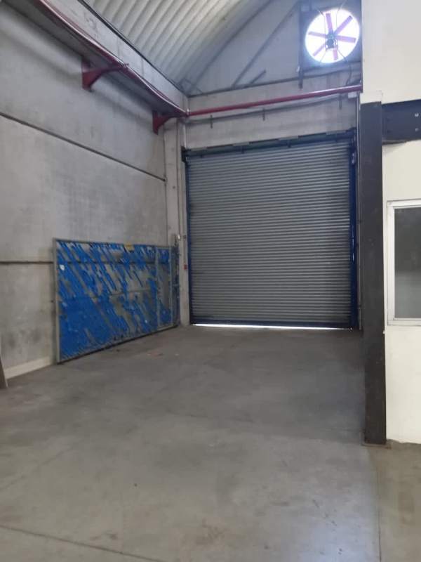 Facade of secured warehouse park with blue accents and control gate Panama City