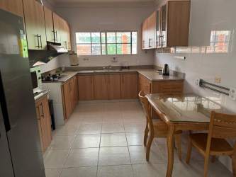 Ample kitchen with U-shaped layout, wood cabinetry, and large window, Costa Verde Colón Panama