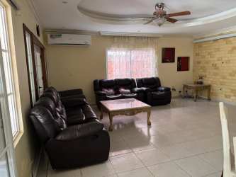 Living space with large sofa, ceiling fan and garden view in Costa Verde Colón Panama