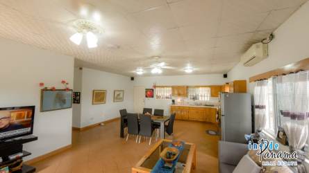 Spacious kitchen and dining with wood cabinets and tiled floor in Pocri Panama home