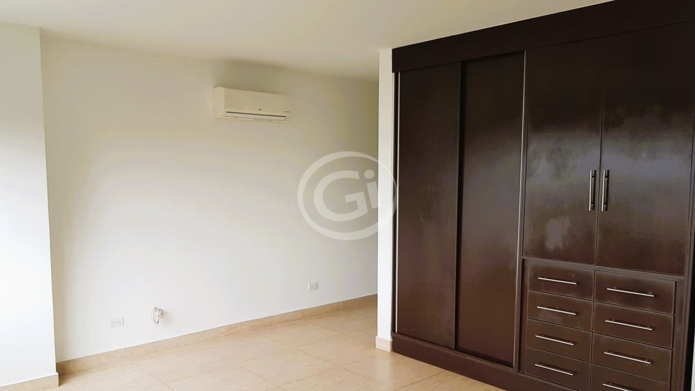 Empty bedroom with beige tiles, built-in wardrobe and AC in Altos de Santa Maria II Condado del Rey Panama