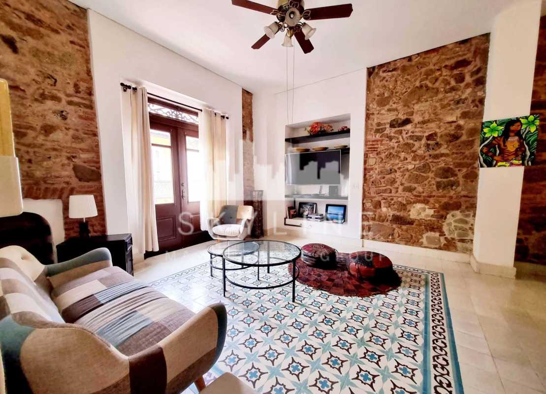 Traditional bedroom with wooden furniture, large wardrobe, window with curtains, balcony access in Casco Viejo Panama