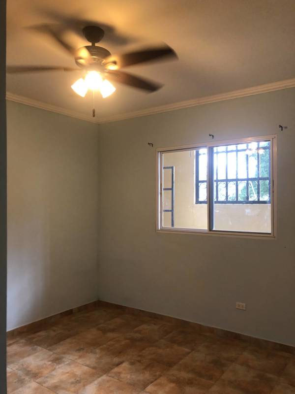 Bedroom with built-in dark wardrobe ceiling fan tiled floors Llano Bonito Panama