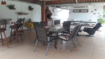 Large covered patio area with barbecue grill, tables and benches in beach property Gorgona Panama
