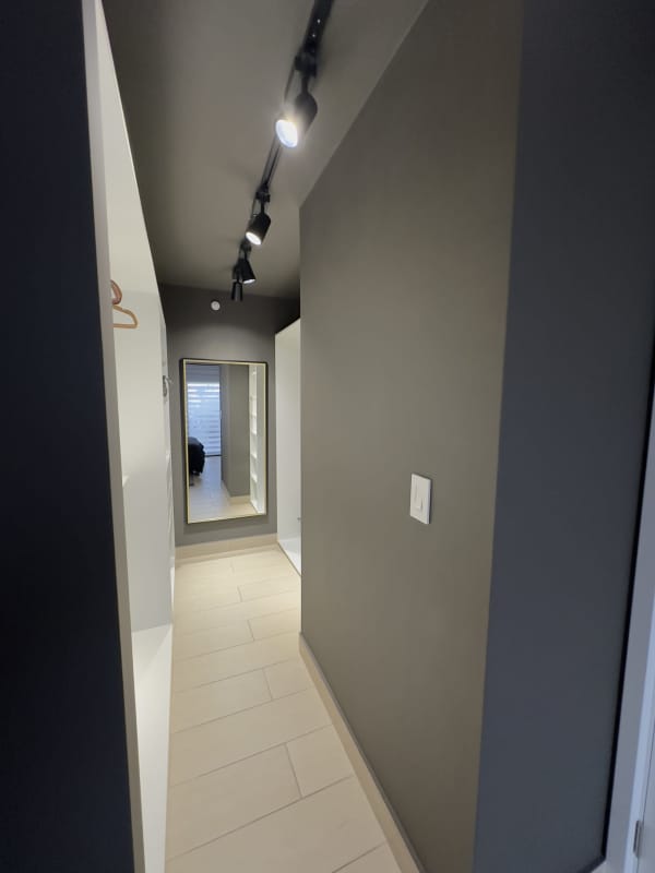Open shelving walk-in closet with woven baskets at Living73 Tower San Francisco