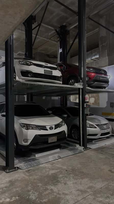 Double-height coworking lounge with large windows and teal wall at Living73 Panama San Francisco