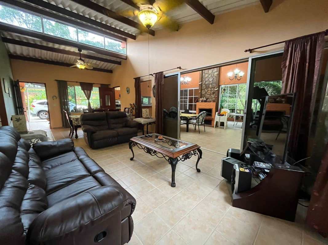Spacious living and dining with high ceiling, wood beams, tiled floor in Cerro Azul mountain house