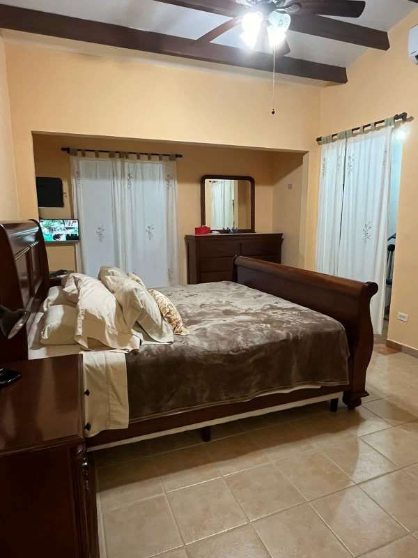 Rustic entrance with orange home, flower pots, lush green landscaping in Cerro Azul