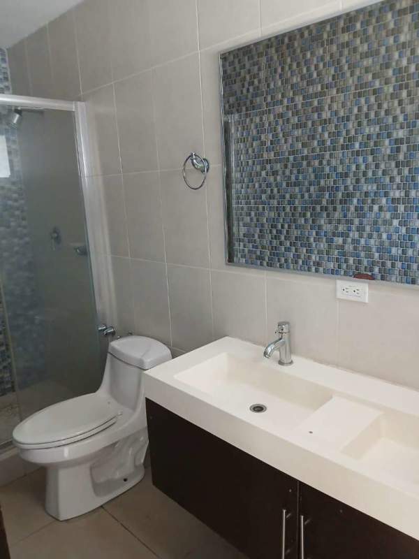 Bathroom with glass shower, dual sinks, mosaic tile mirror in PH Miyaki Obarrio Panama