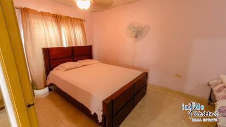 Bedroom with pink walls tiled floor en suite bathroom in Pocri guesthouse Panama