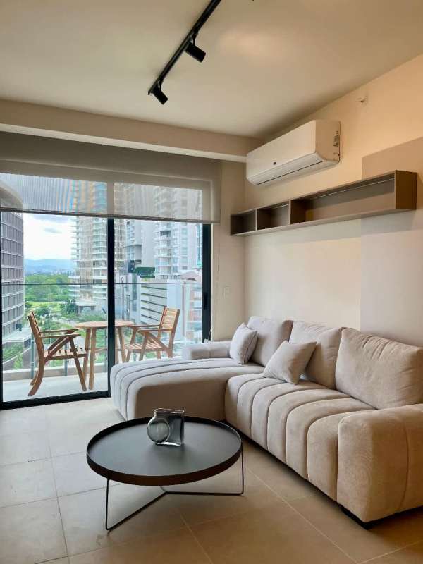 Family room adjacent to open kitchen with golf views in Santa María condominium Panama