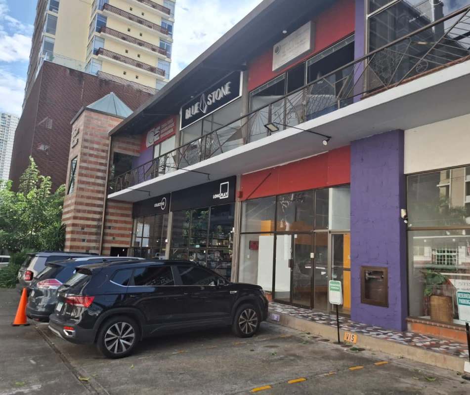 Colorful two-level commercial retail complex with signage balcony and parking San Francisco Panama