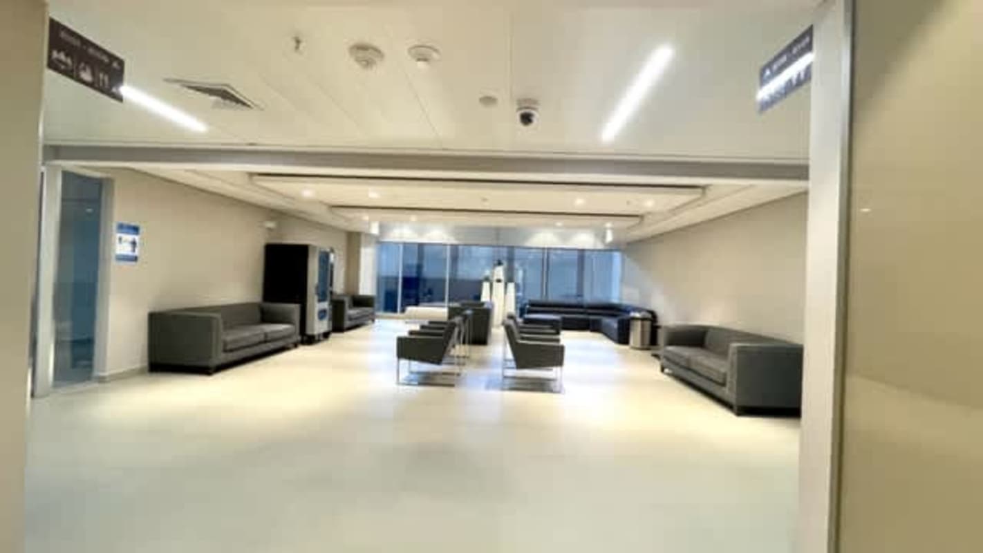 Empty modern office with large internal window, neutral tiles, prepared for rent in Panama City