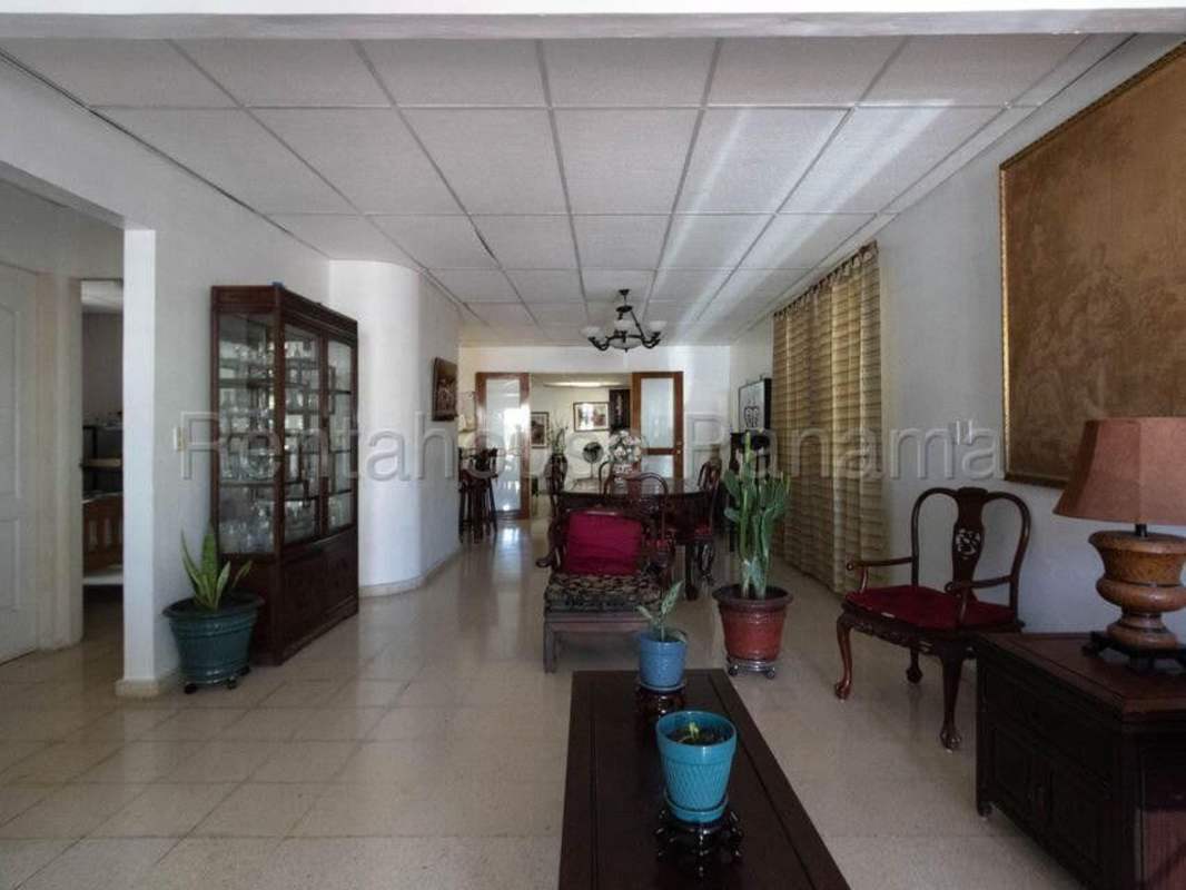 Spacious dining room with chandelier and wooden furniture in Villa Lucre house