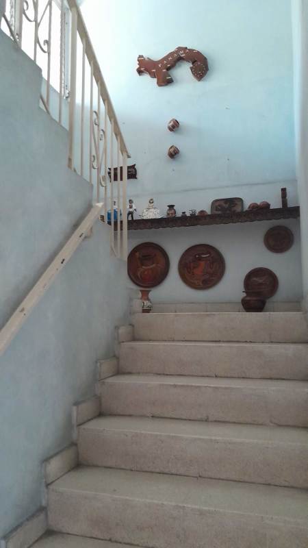 Traditional indoor staircase with stone steps, decorative items, in Chanis duplex house for sale Panama