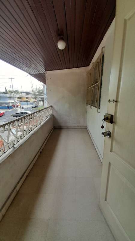 Covered balcony with iron railing and wood ceiling overlooking residential street Chanis Panama