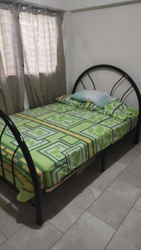 Basic student room with window, metal bed frame and curtain PH Prosperidad Bethania Panama City