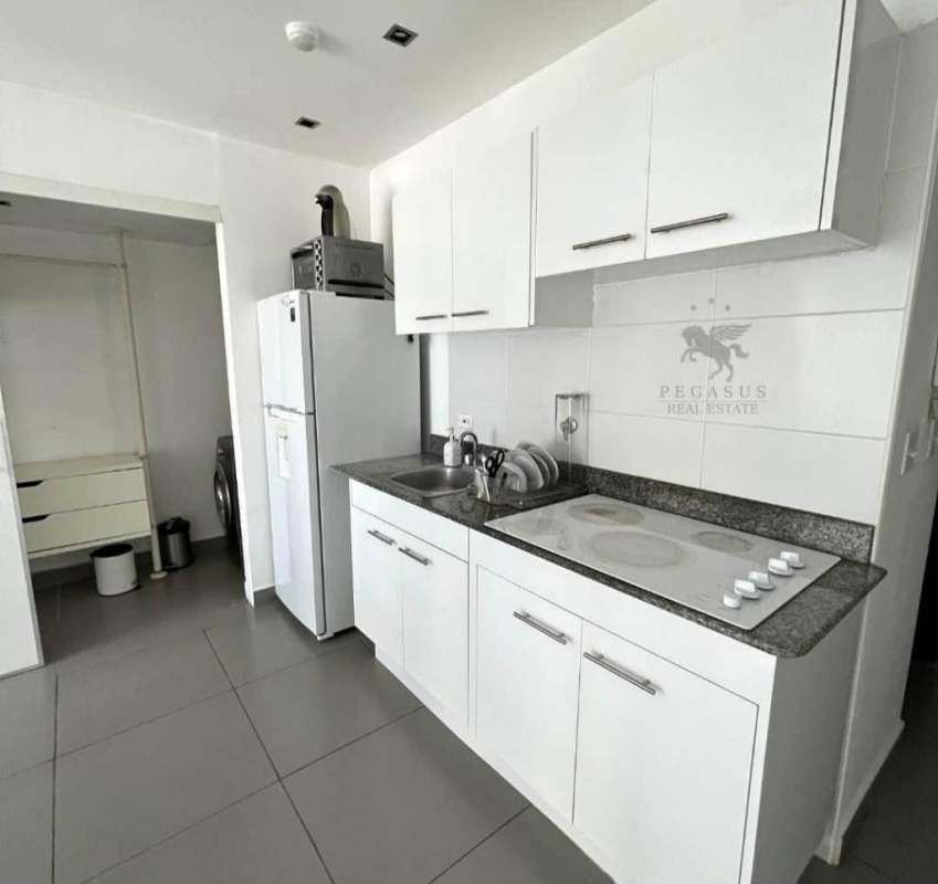 Compact granite-top white kitchen with appliances studio apartment PH Colores Bella Vista
