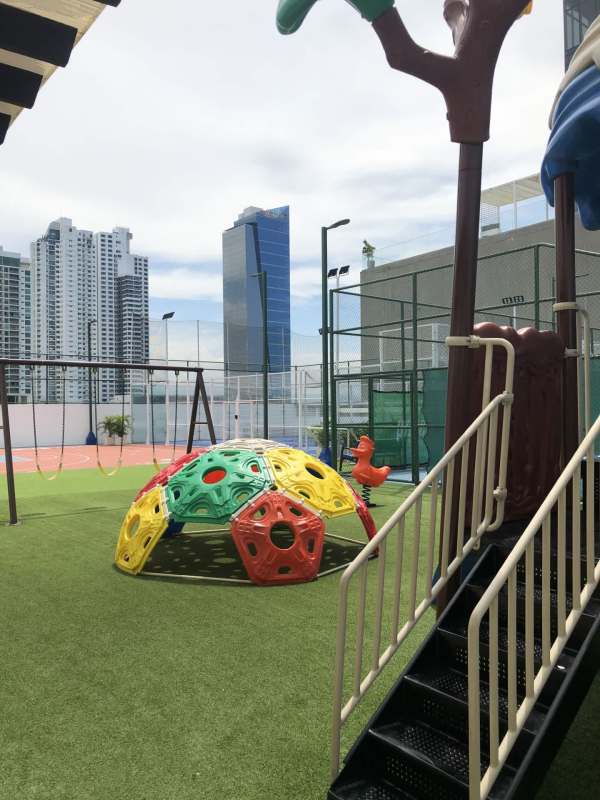 Colorful children's playground equipment with skyline views in PH Paramount Costa del Este residential community